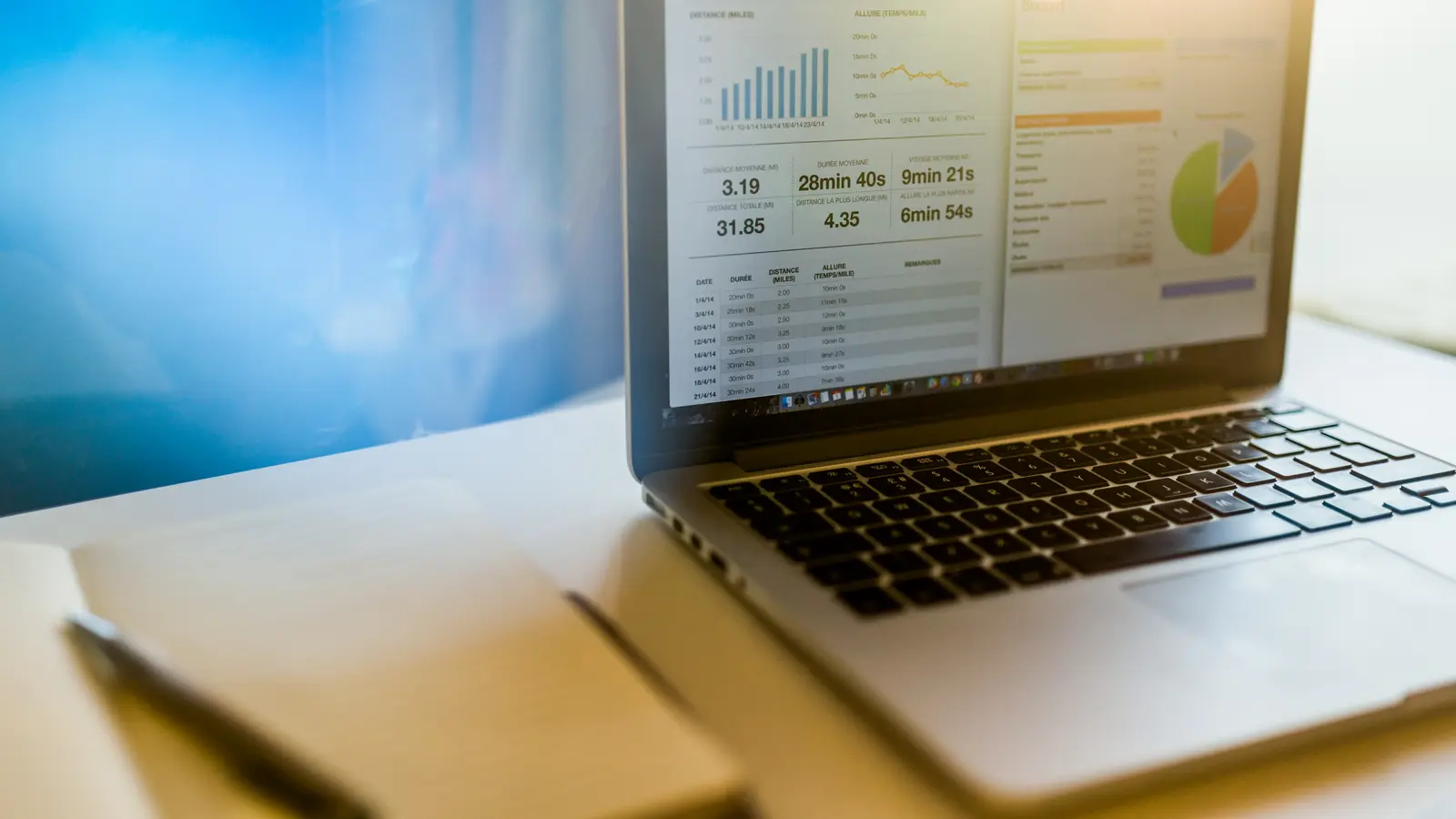 Ordinateur portable ouvert sur un tableau de chiffres, posé sur un bureau lumineux